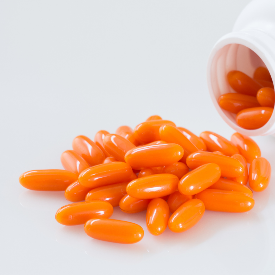 orange capsules pouring out of a pill bottle