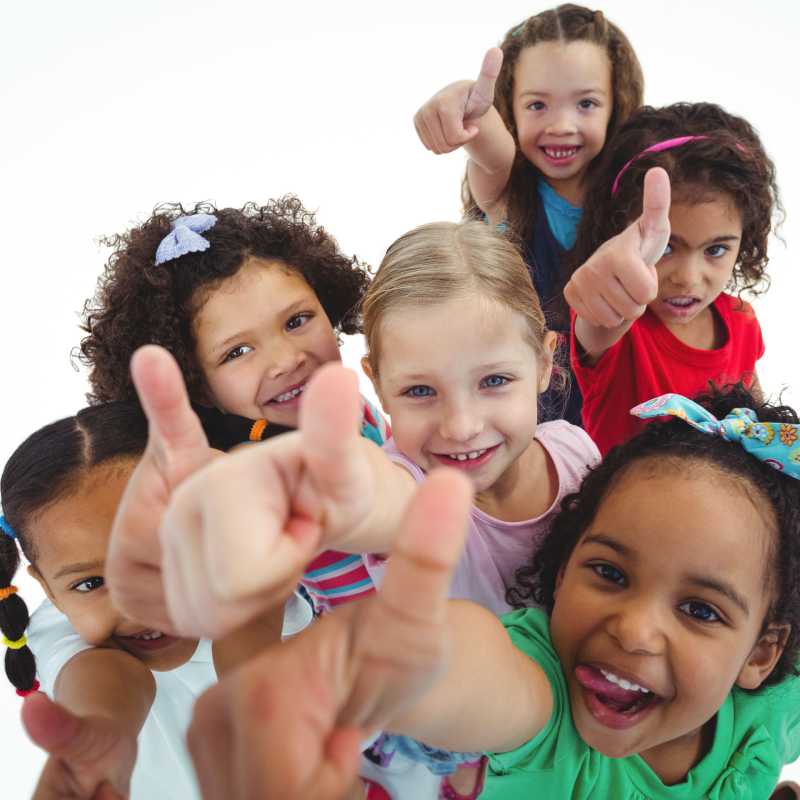 a group of young kids all showing a thumbs-up