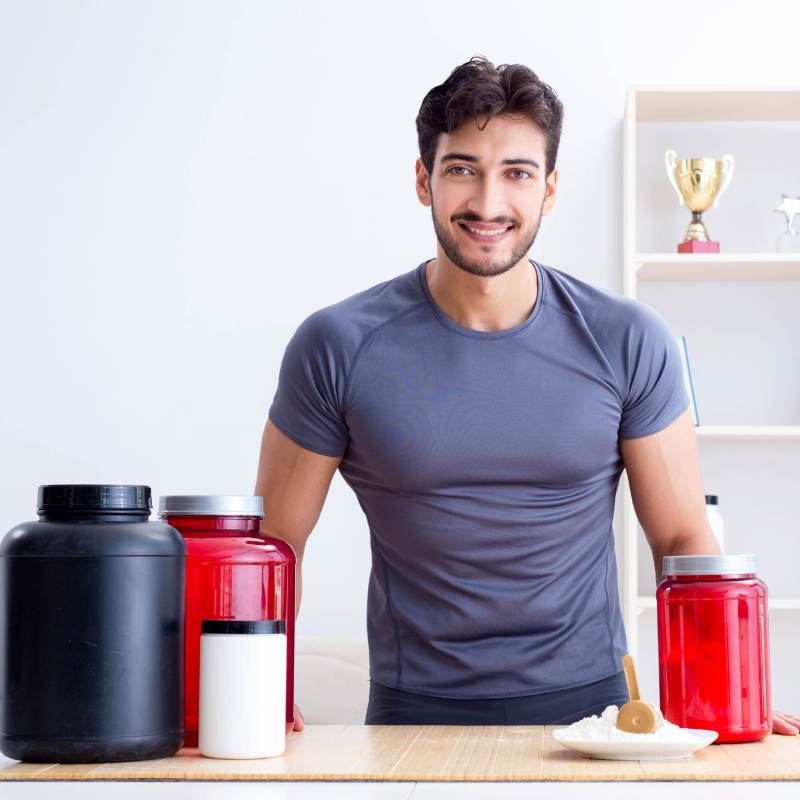 Smiling man with supplements kept on table